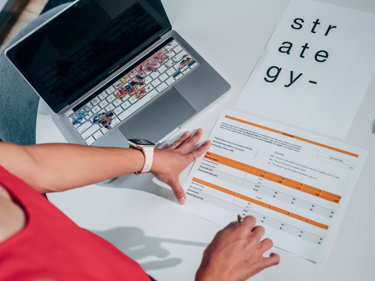 Overhead view of hands on business strategy papers with laptop, highlighting modern planning.